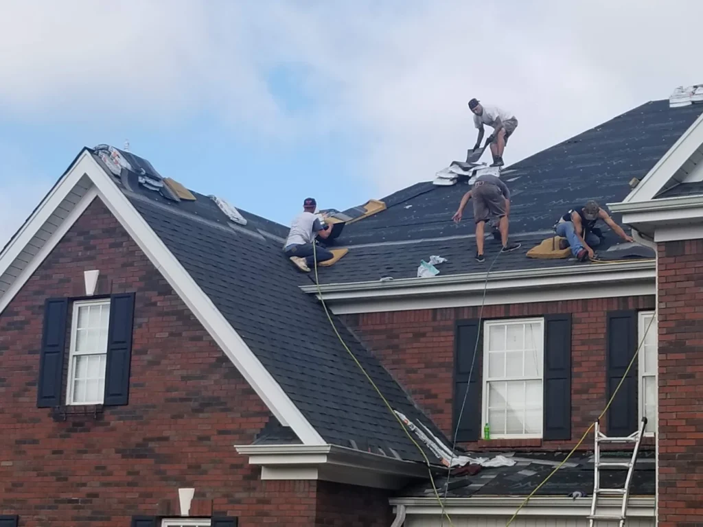 Roofing crew installing new architectural shingles on a two-story brick home in Spartanburg SC during a full roof replacement. roof replacement Spartanburg