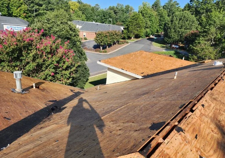 Roof replacement in Spartanburg SC with old shingles removed and roof decking exposed during inspection before installing new materials.